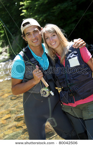 stock-photo-portrait-of-couple-fly-fishing-in-river-80042506